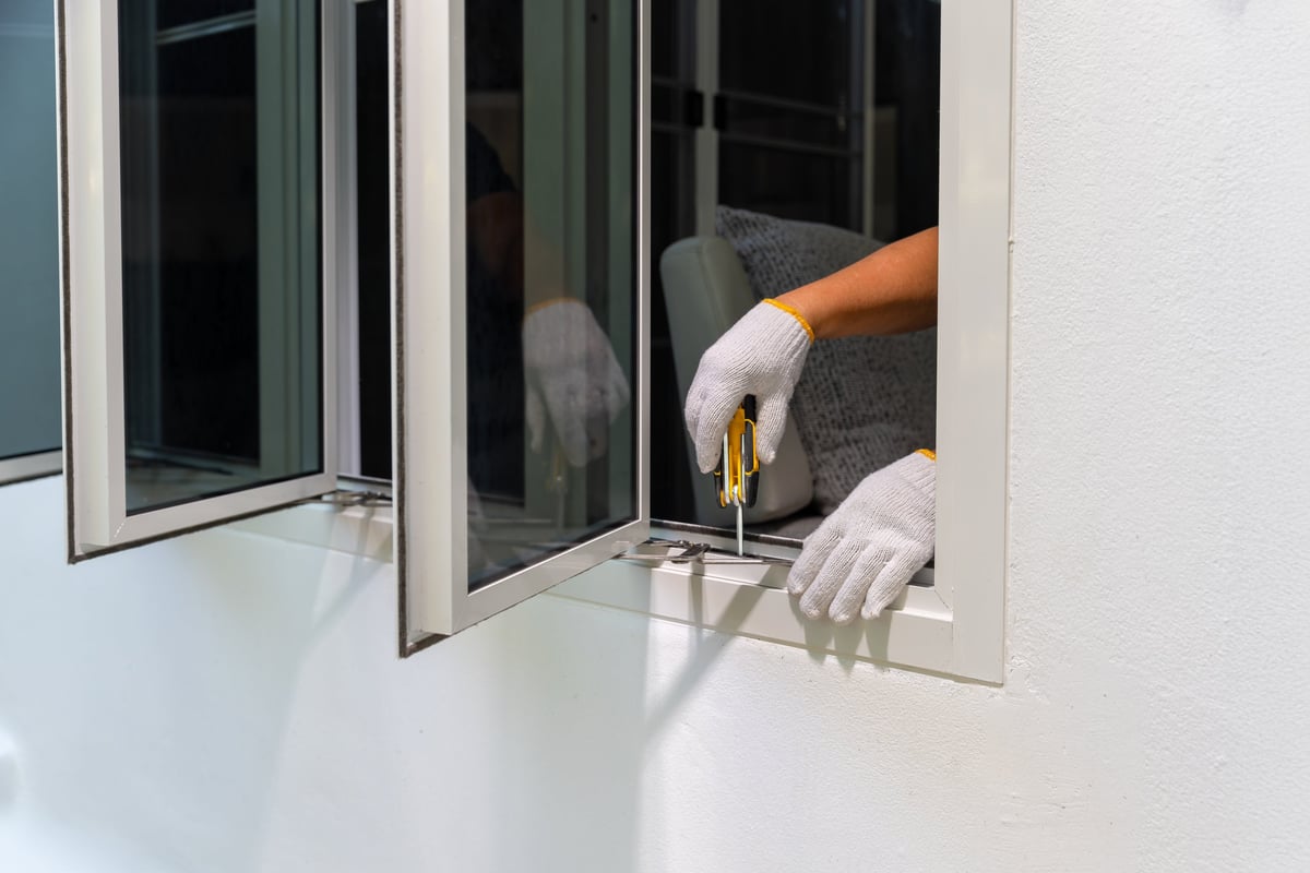 Craftsperson adjusting the friction stay on a casement window